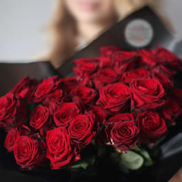 Bouquet of red roses wrapped in black paper