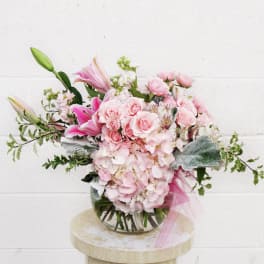 Pink roses and lilies arranged in a glass vase