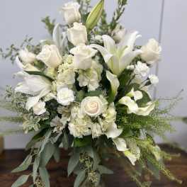 White roses, lilies, and calla lilies in a glass vase