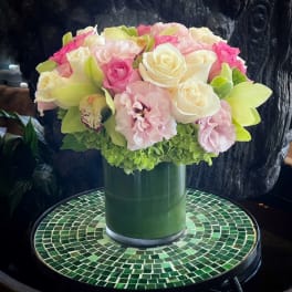 Pink and white rose bouquet in a green vase