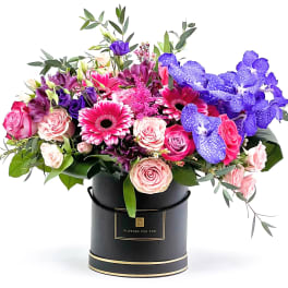 Bouquet of pink and purple flowers in a black hat box