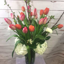 Tulip arrangement in a glass vase with white hydrangeas