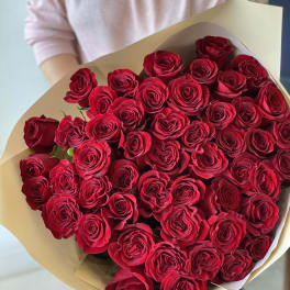 Large bouquet of red roses wrapped in beige paper