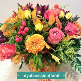 Colorful bouquet of roses and marigolds with autumn leaves