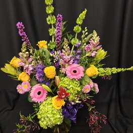 Colorful mixed flower arrangement with pink gerberas and yellow roses in a vase