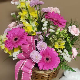 Basket arrangement with pink gerbera daisies and yellow snapdragons