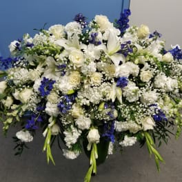 Large white and blue floral arrangement in a dark container