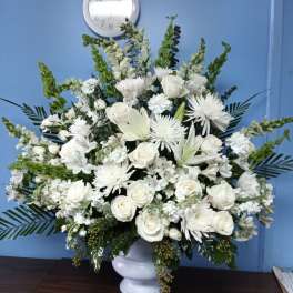 White floral arrangement in a white pedestal vase