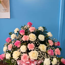 Pink and white rose and carnation arrangement with a pink ribbon