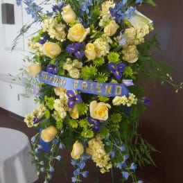 Tall floral standing spray with yellow roses and blue flowers