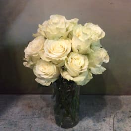 White roses arranged in a clear glass vase
