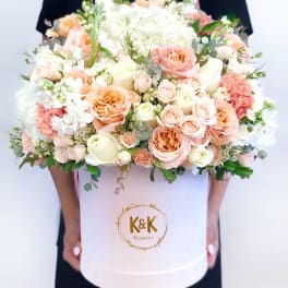 Large pastel bouquet of roses, hydrangeas, and carnations in a white hat box