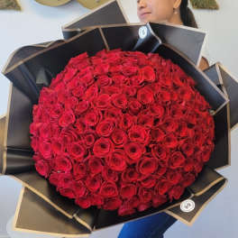 Large bouquet of red roses wrapped in black paper