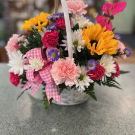 Basket of mixed flowers with a pink gingham ribbon