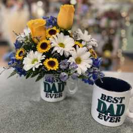 Bouquet of yellow roses, daisies, and blue flowers in a mug beside a matching Dad mug