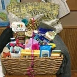 Gift basket with assorted packaged items and a pink ribbon