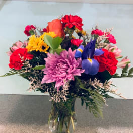 Mixed bouquet of colorful flowers in a clear glass vase