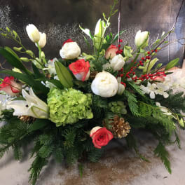 Holiday floral arrangement with white lilies, red roses, and green hydrangea