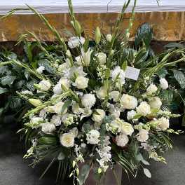Large white floral funeral spray with roses and lilies
