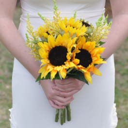 Bride holding a bouquet of yellow sunflowers with airy filler flowers