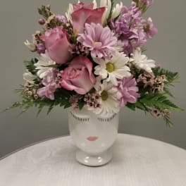 Pink and white mixed bouquet in a white face vase
