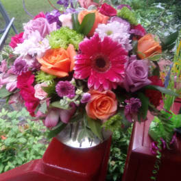 Mixed bouquet with roses, gerbera daisies, and chrysanthemums in bright pink, orange, and purple