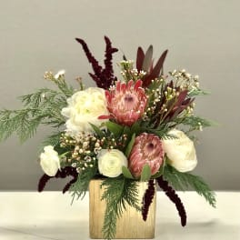 Mixed bouquet in a gold square vase with pink and white blooms