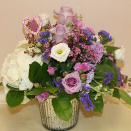 Lavender and white rose arrangement in a silver vase with a pink heart pick