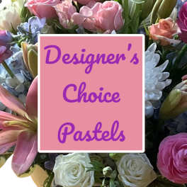 Pastel flower arrangement with roses, lilies, and daisies behind a pink sign