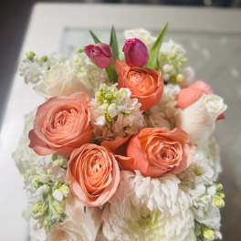 Bouquet of coral roses, white blooms, and pink tulips