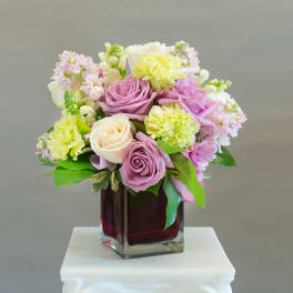 Pastel rose and carnation bouquet in a square glass vase