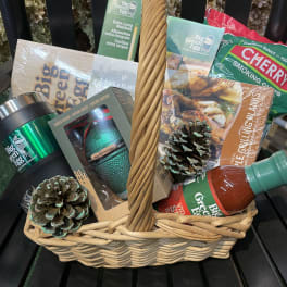 Basket of grilling gifts with matches, sauces, and pinecone decorations