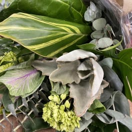 Bouquet of assorted green foliage with a few pale green blooms