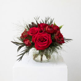 Red roses arranged in a clear glass vase