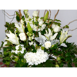 White floral arrangement with roses, lilies, and hydrangeas