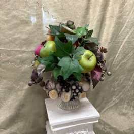 Fruit arrangement with apples and grapes in a decorative vase