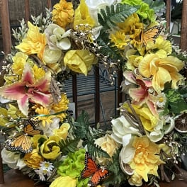 Yellow and white floral wreath with butterflies and greenery