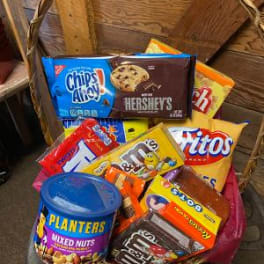 Basket filled with assorted candy bars and a can of mixed nuts