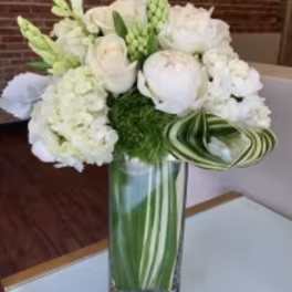 White floral arrangement in a tall glass vase