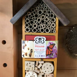 Wooden insect house with bamboo tubes and drilled wood blocks