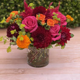 Bouquet of pink and orange flowers in a clear glass vase