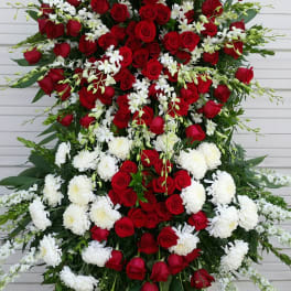 Large standing spray of red roses and white flowers on an easel