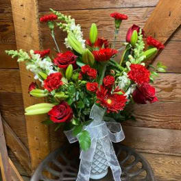 Red and white mixed bouquet with lilies and roses in a white vase
