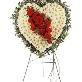 Heart-shaped floral standing spray with red and white flowers on an easel
