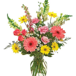 Mixed bouquet of pink roses and yellow daisies in a glass vase