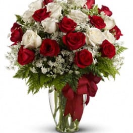 Red and white roses arranged in a clear glass vase