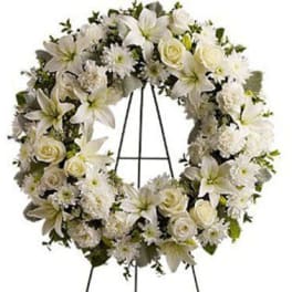 White floral wreath on a black stand