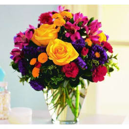 Colorful bouquet of roses and mixed flowers in a glass vase