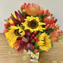 Bouquet of yellow sunflowers with burgundy and orange tropical blooms