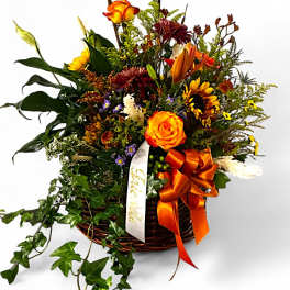 Autumn floral basket with orange roses and sunflowers